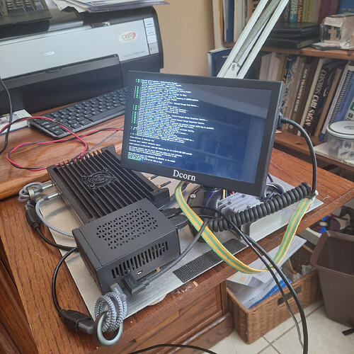 Boîtier KrakenSDR relié à un Raspberry Pi et un petit écran affichant le journal de démarrage, sur un poste de test